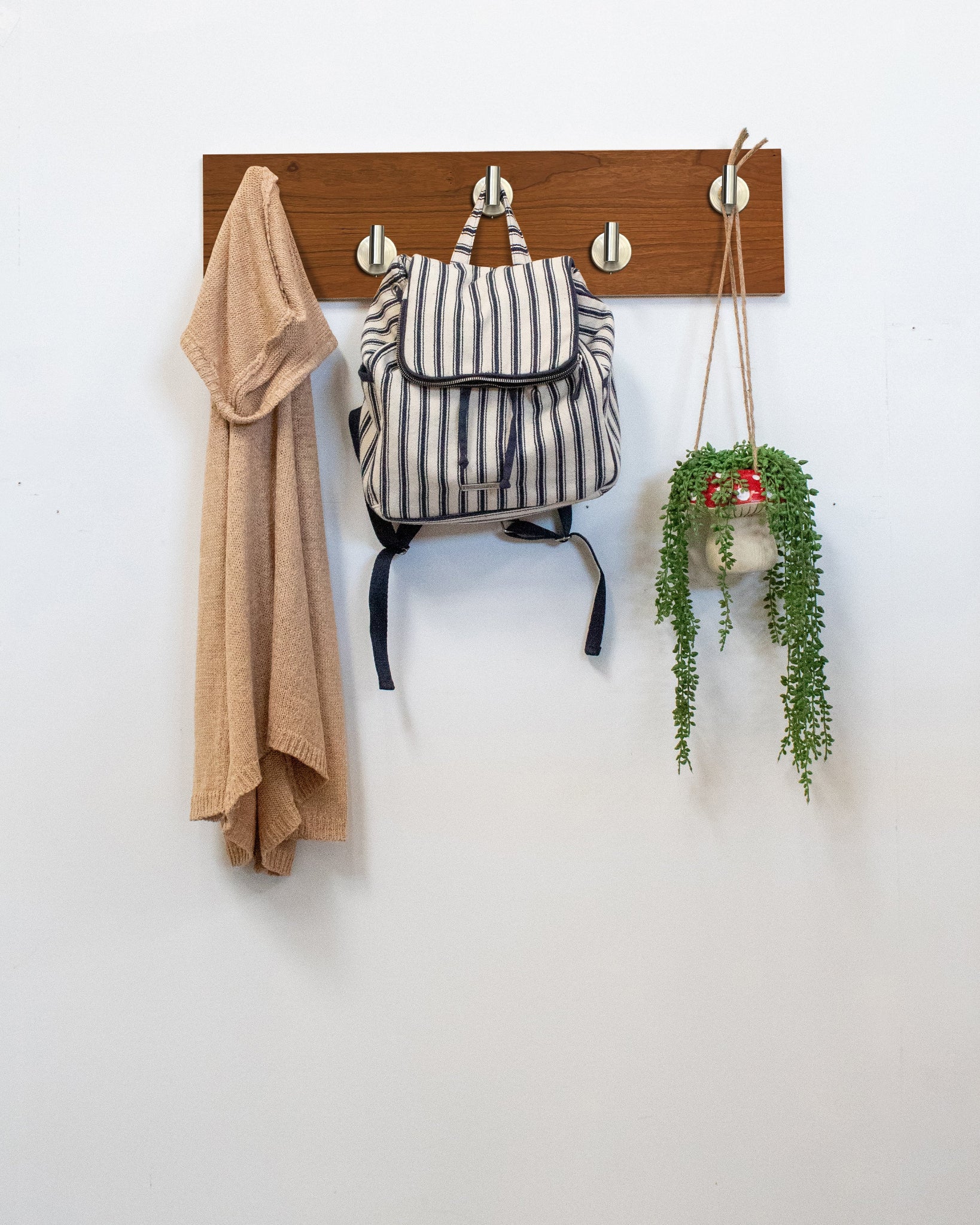 Cherry Wood wall hook rack satin nickel hooks with a backpack, coat, and plant