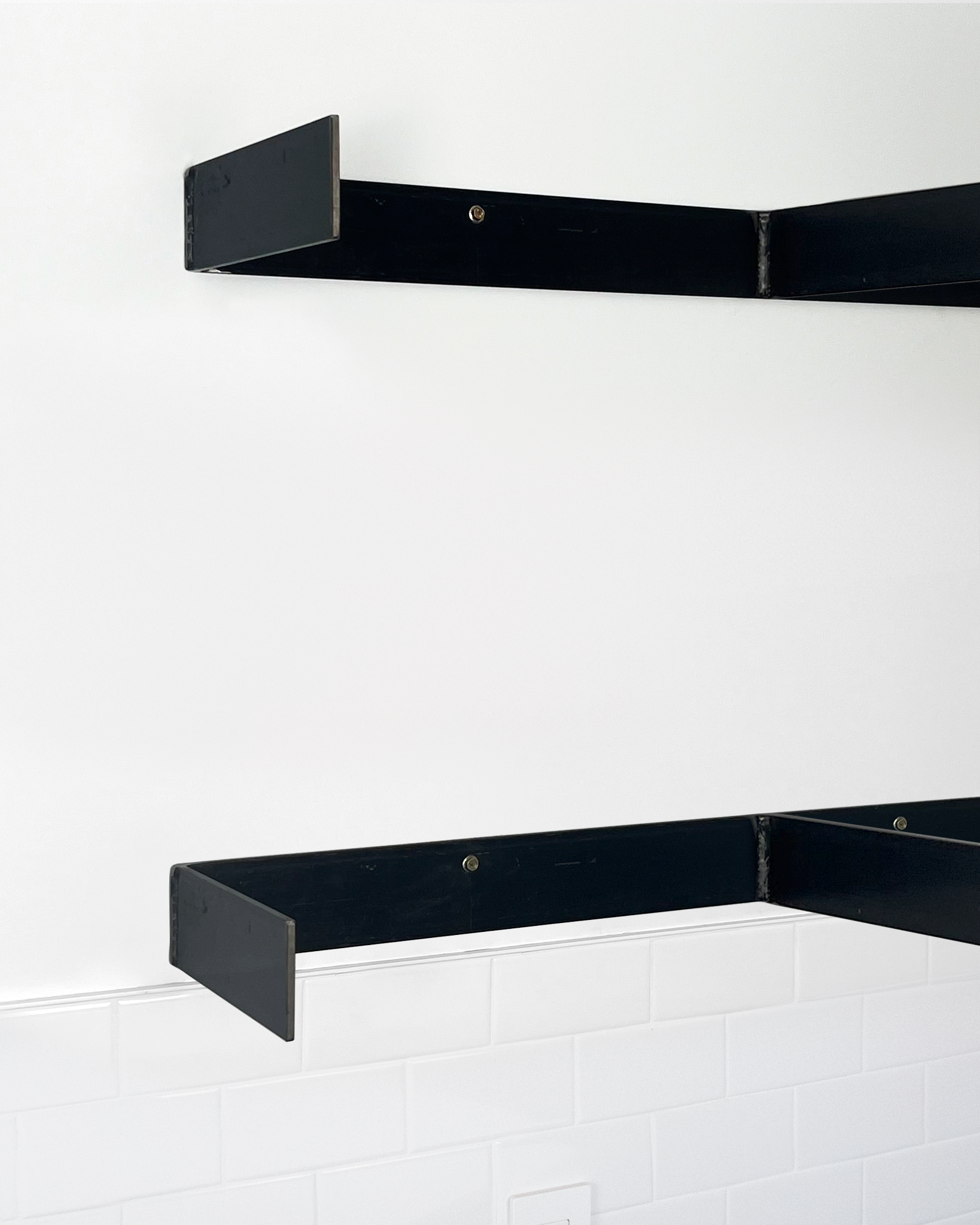 Two metal brackets mounted on a wall