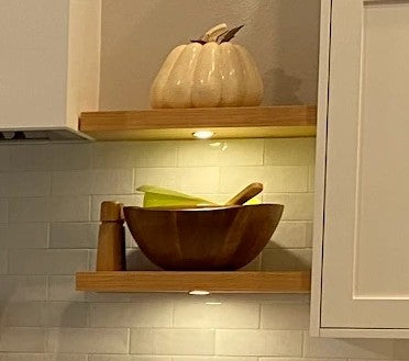 Wood floating shelves with integrated puck lights.
