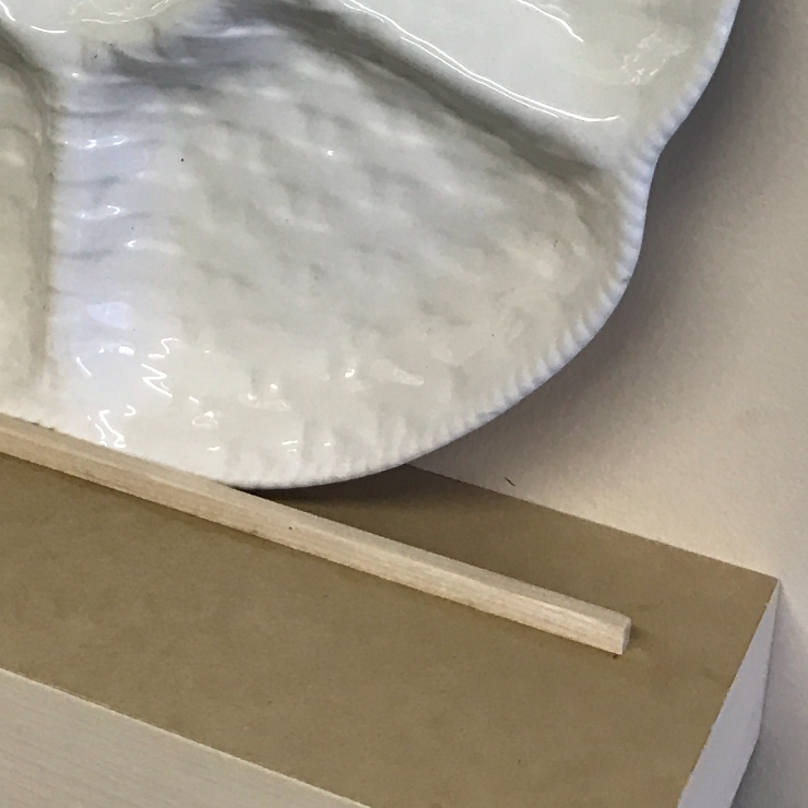 closeup of a floating shelf with a lip displaying a plate