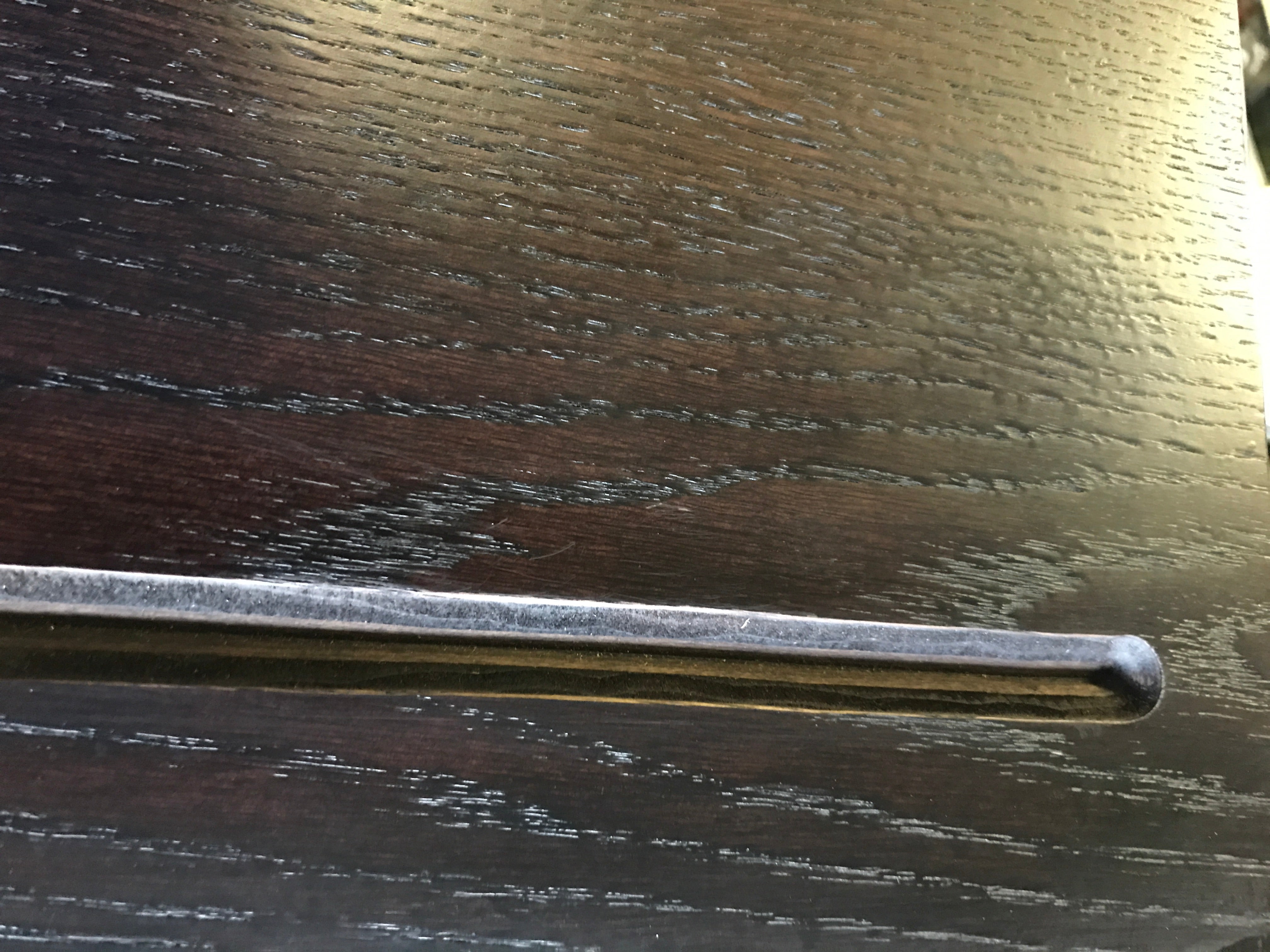 Closeup of groove cut out of black floating shelf