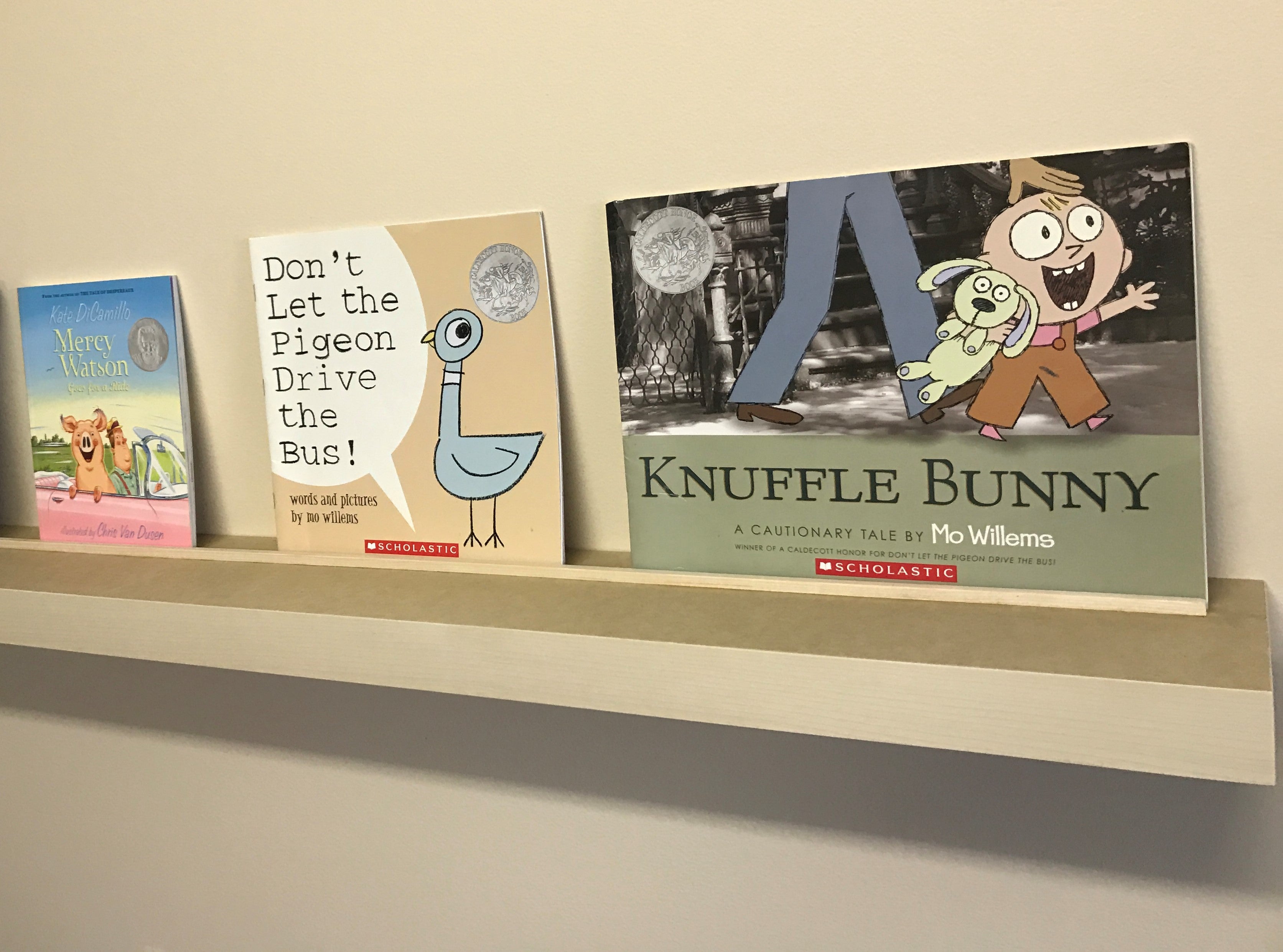 Front view of custom floating shelf holding three books