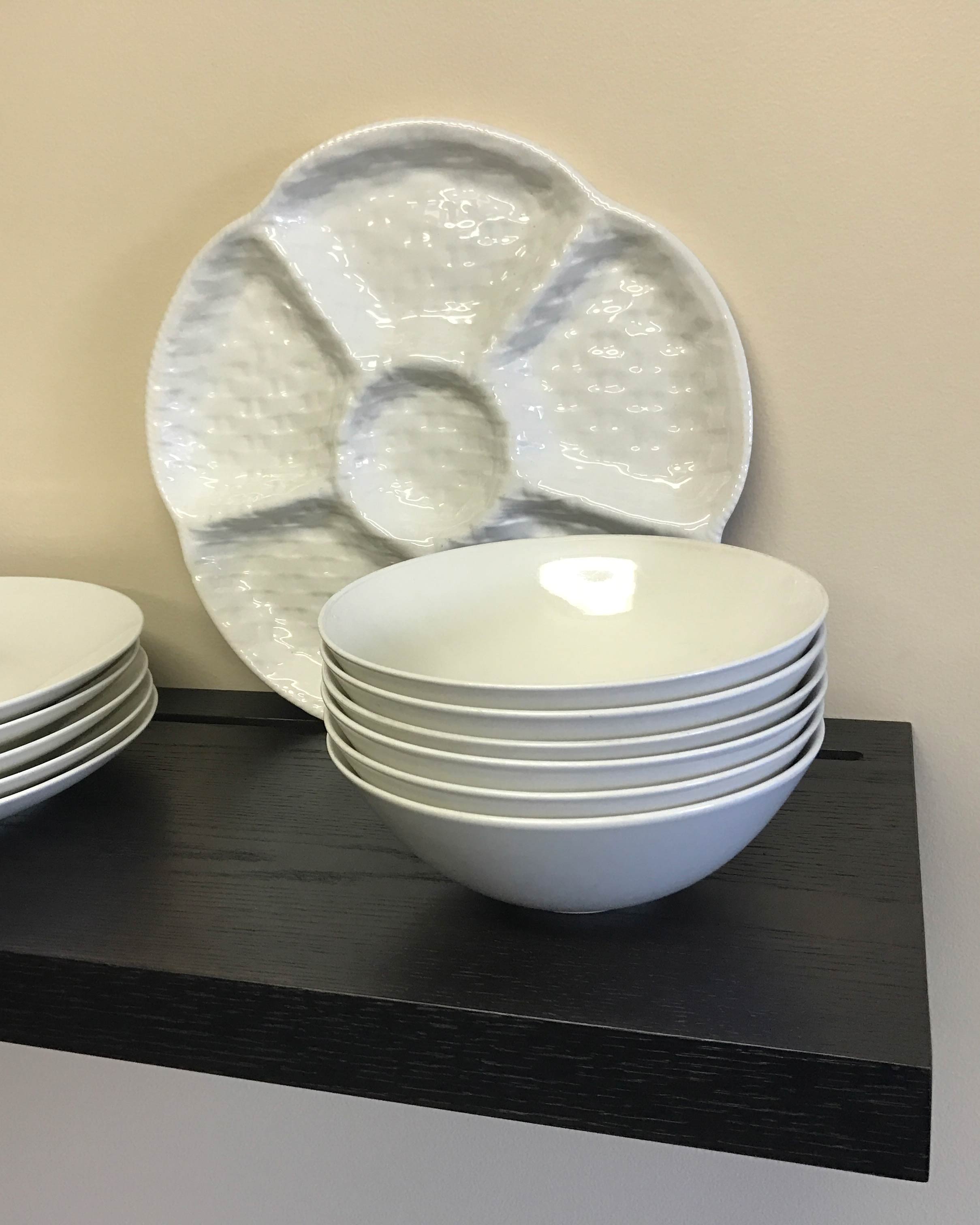 black floating shelf with groove holding dishes