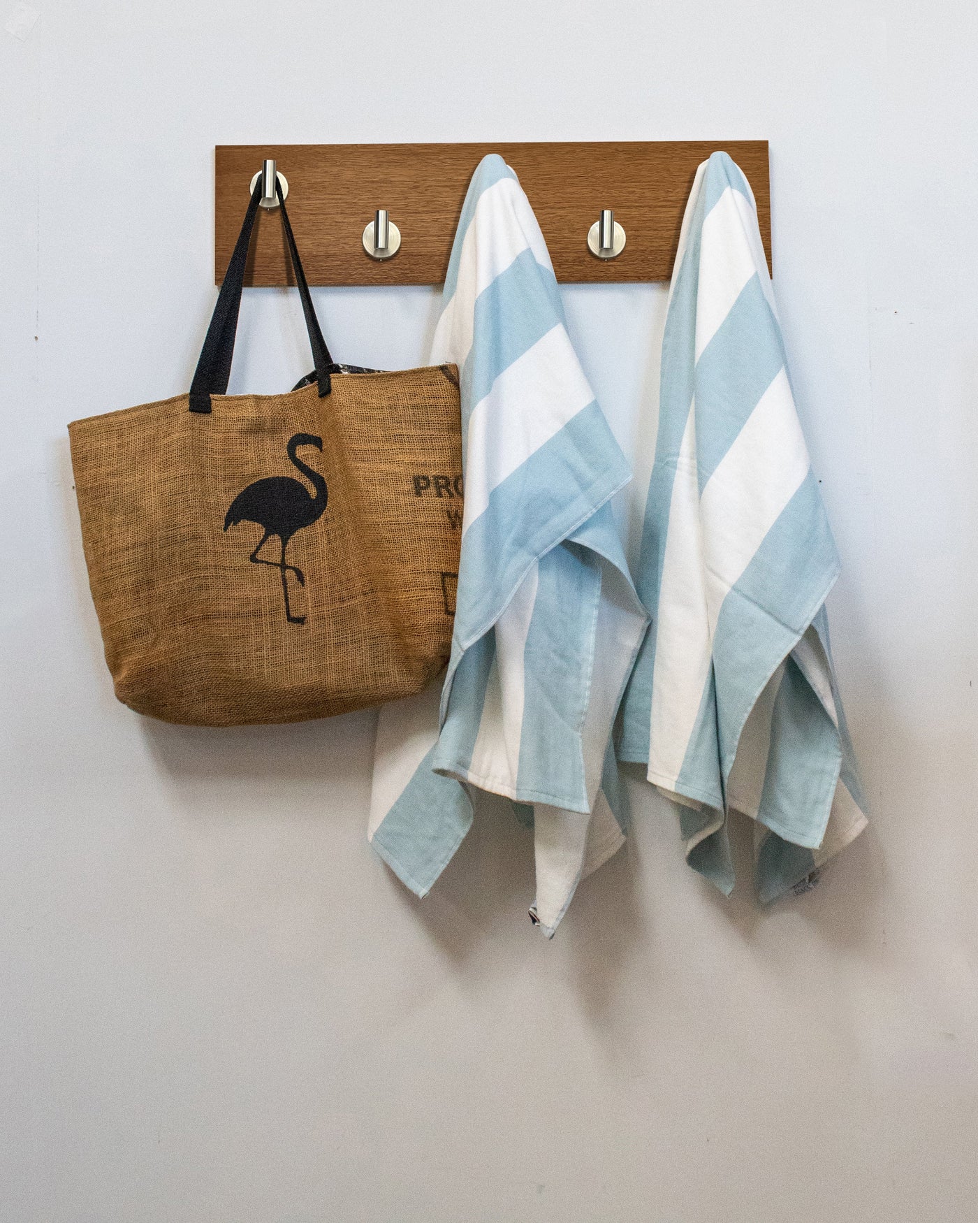 African mahogany wood wall hook rack brown tote bag with flamingo design and two striped towels hanging on 5 satin nickel hooks 