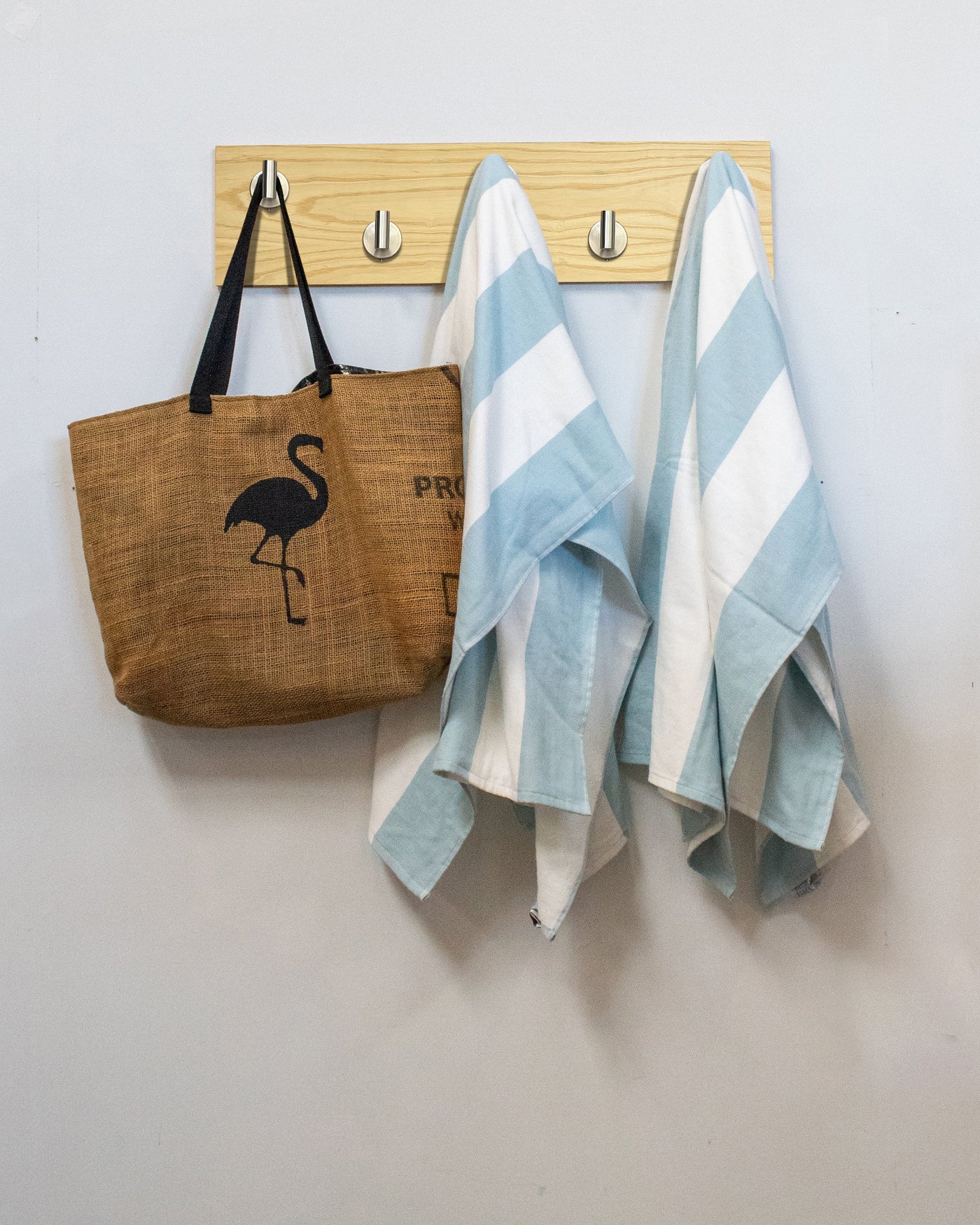 Ash wood wall hook rack brown tote bag with flamingo design and two striped towels hanging on 5 satin nickel hooks 
