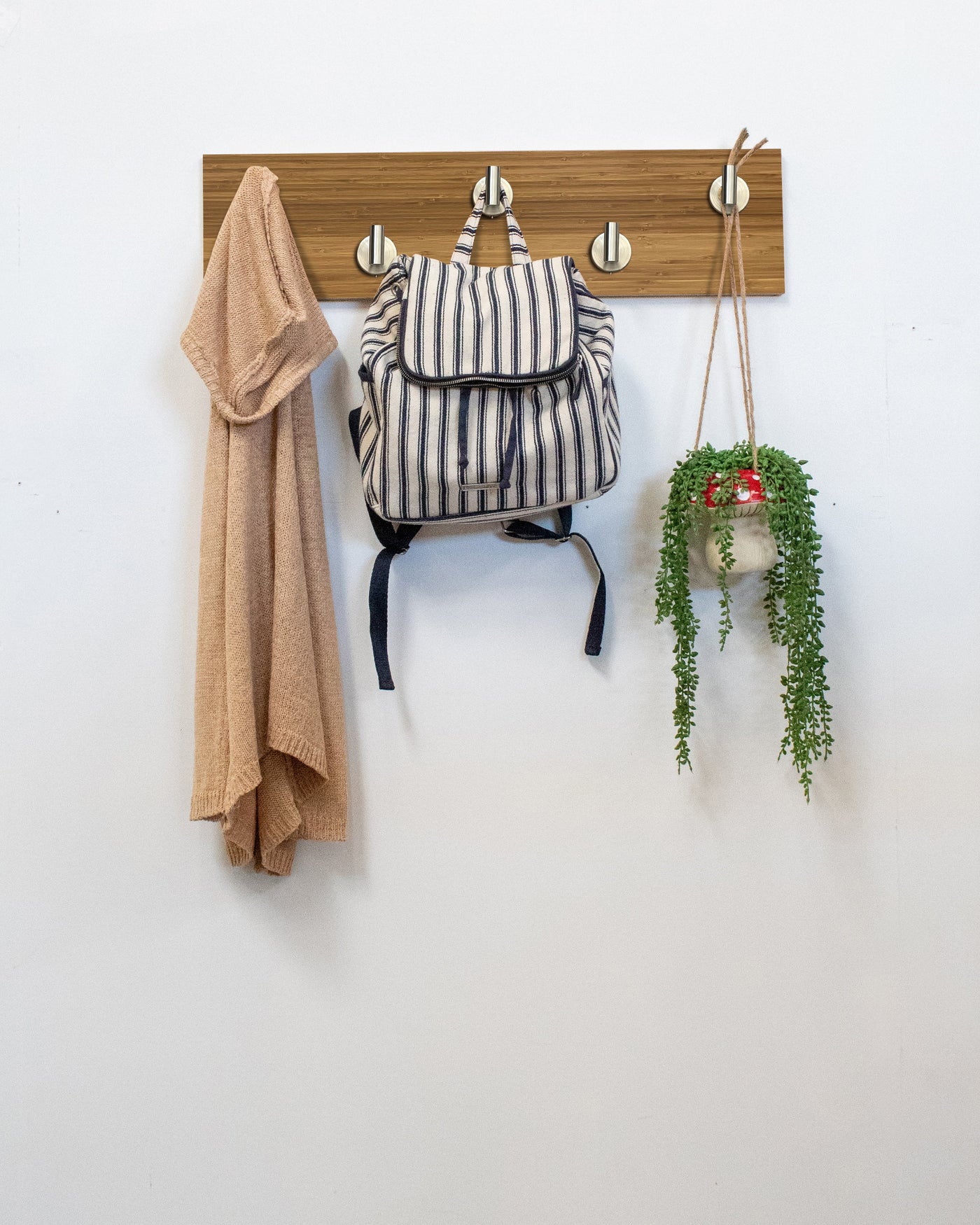 Bamboo Wood wall hook rack satin nickel hooks with a backpack, coat, and plant