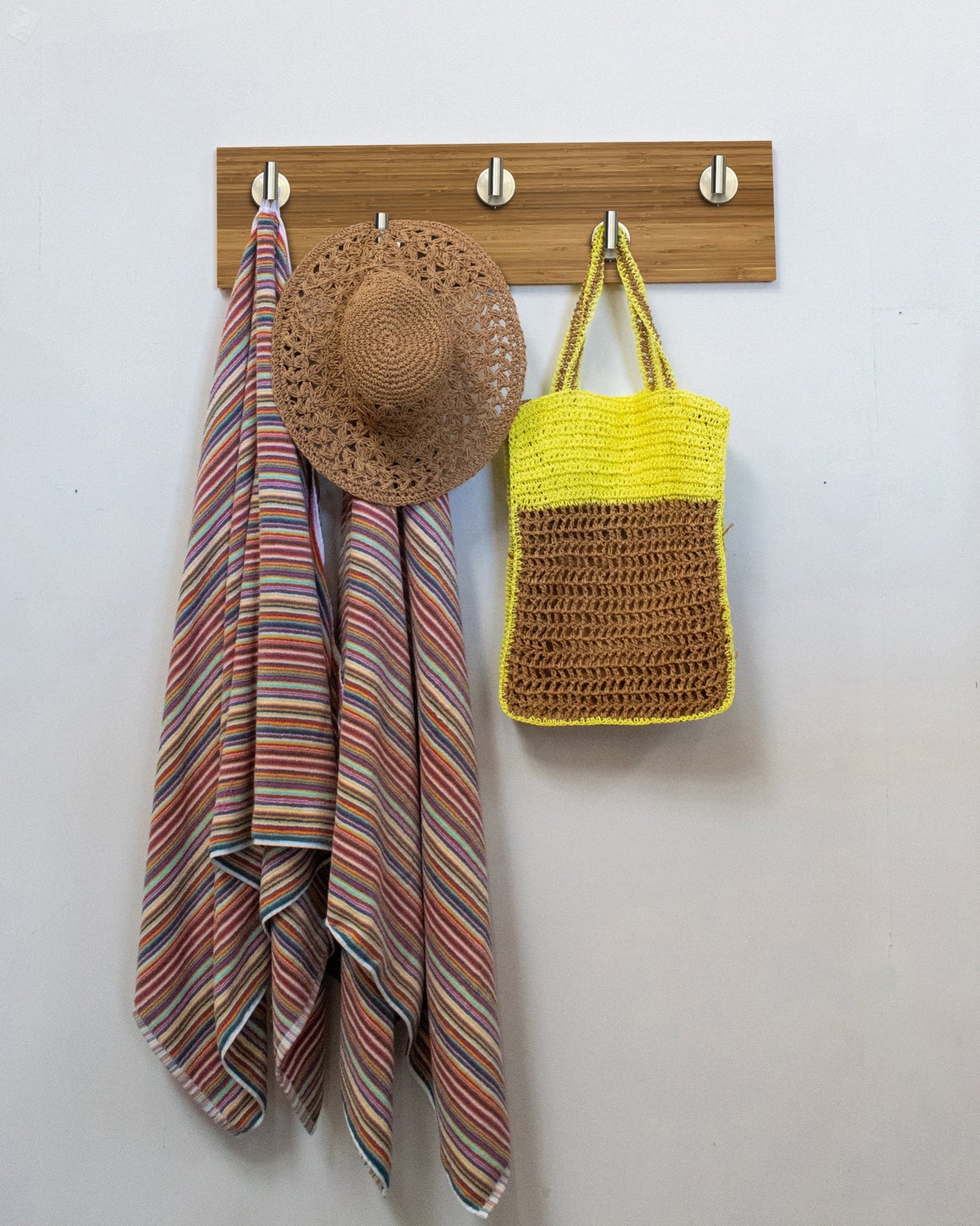 Bamboo wood wall hook rack with 5 satin nickel hooks, striped towel, straw hat, and yellow bag