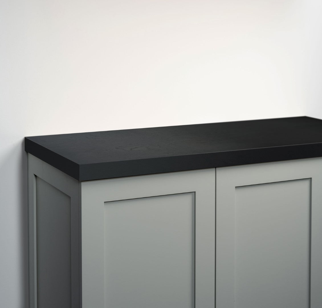 A close-up of a modern cabinet with a matte black countertop