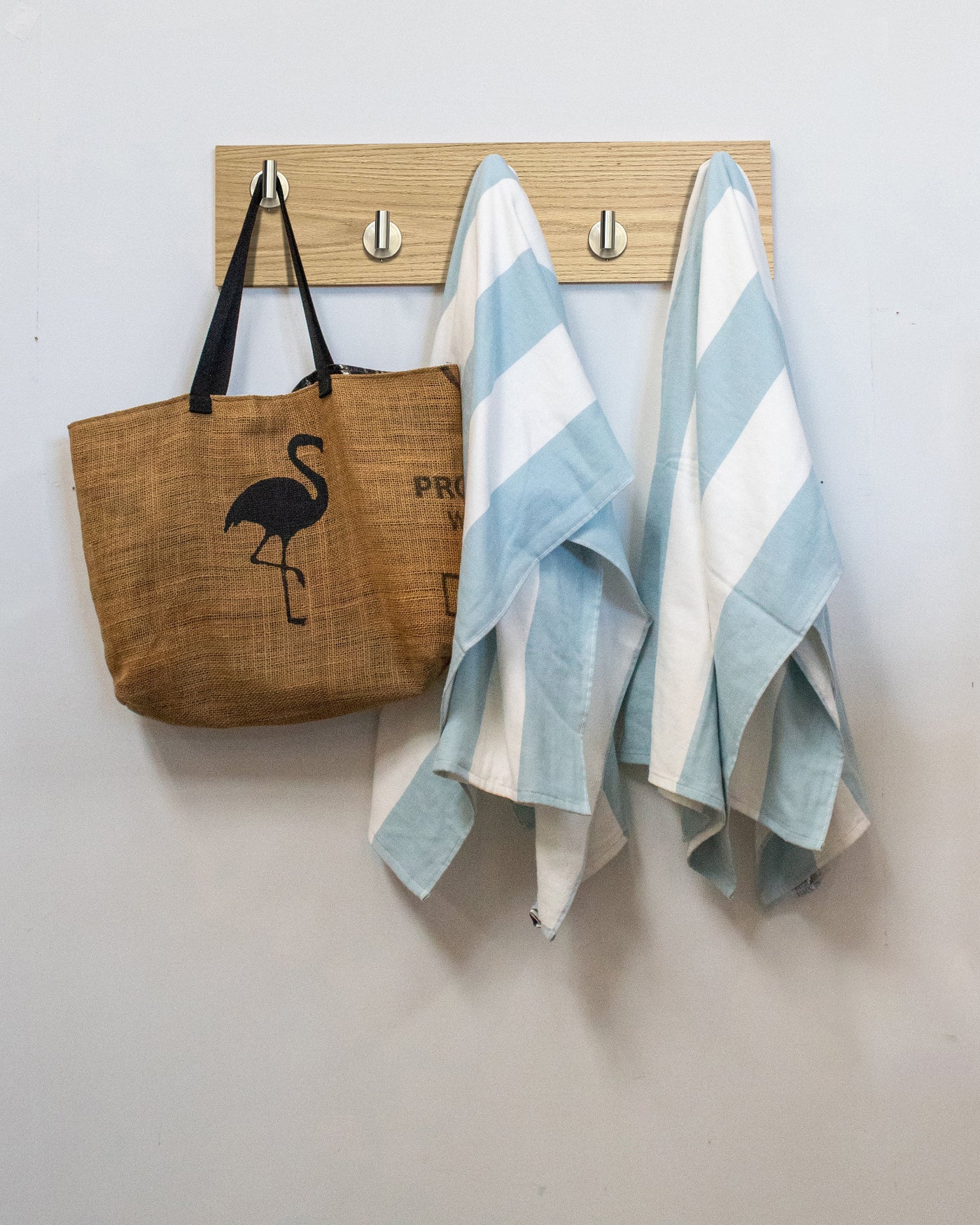 Bleached oak wood wall hook rack brown tote bag with flamingo design and two striped towels hanging on 5 satin nickel hooks 