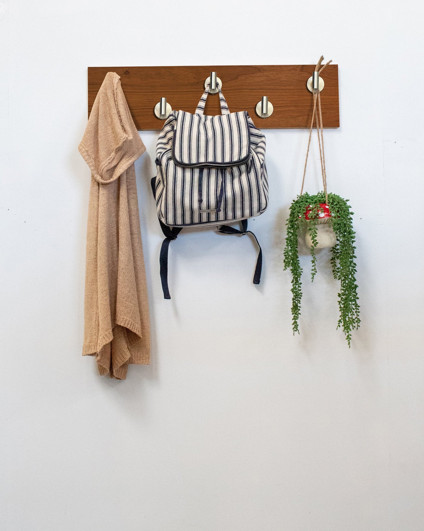 Cherry Wood wall hook rack satin nickel hooks with a backpack, coat, and plant