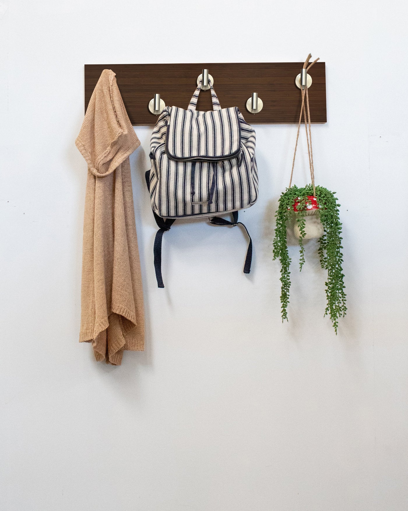 Chocolate Bamboo Wood wall hook rack satin nickel hooks with a backpack, coat, and plant