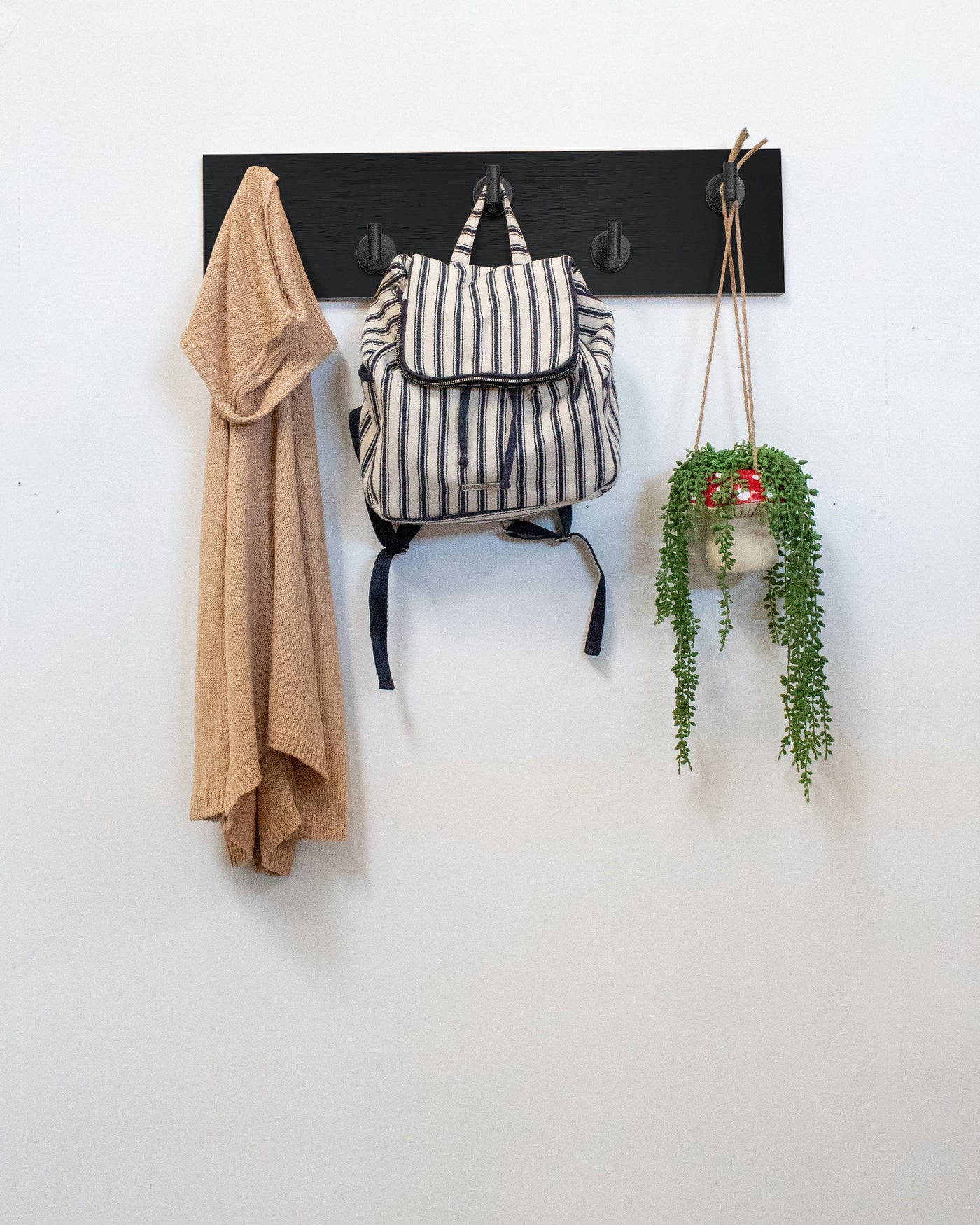 Chocolate espresso oak 5 hook rack matte black hooks with a backpack, coat, and plant