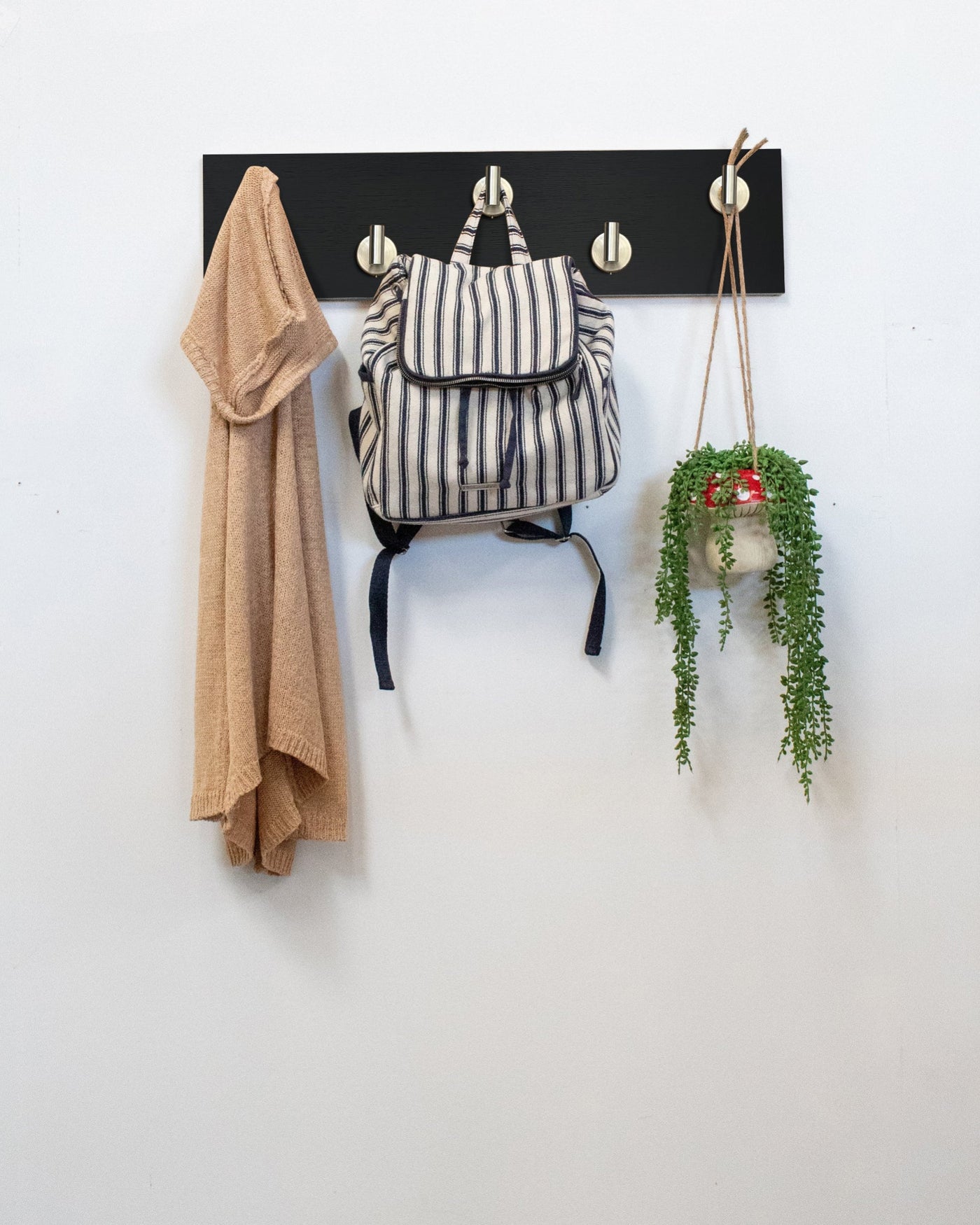 Chocolate espresso oak wall hook rack with 5 satin nickel hooks with a backpack, coat, and plant