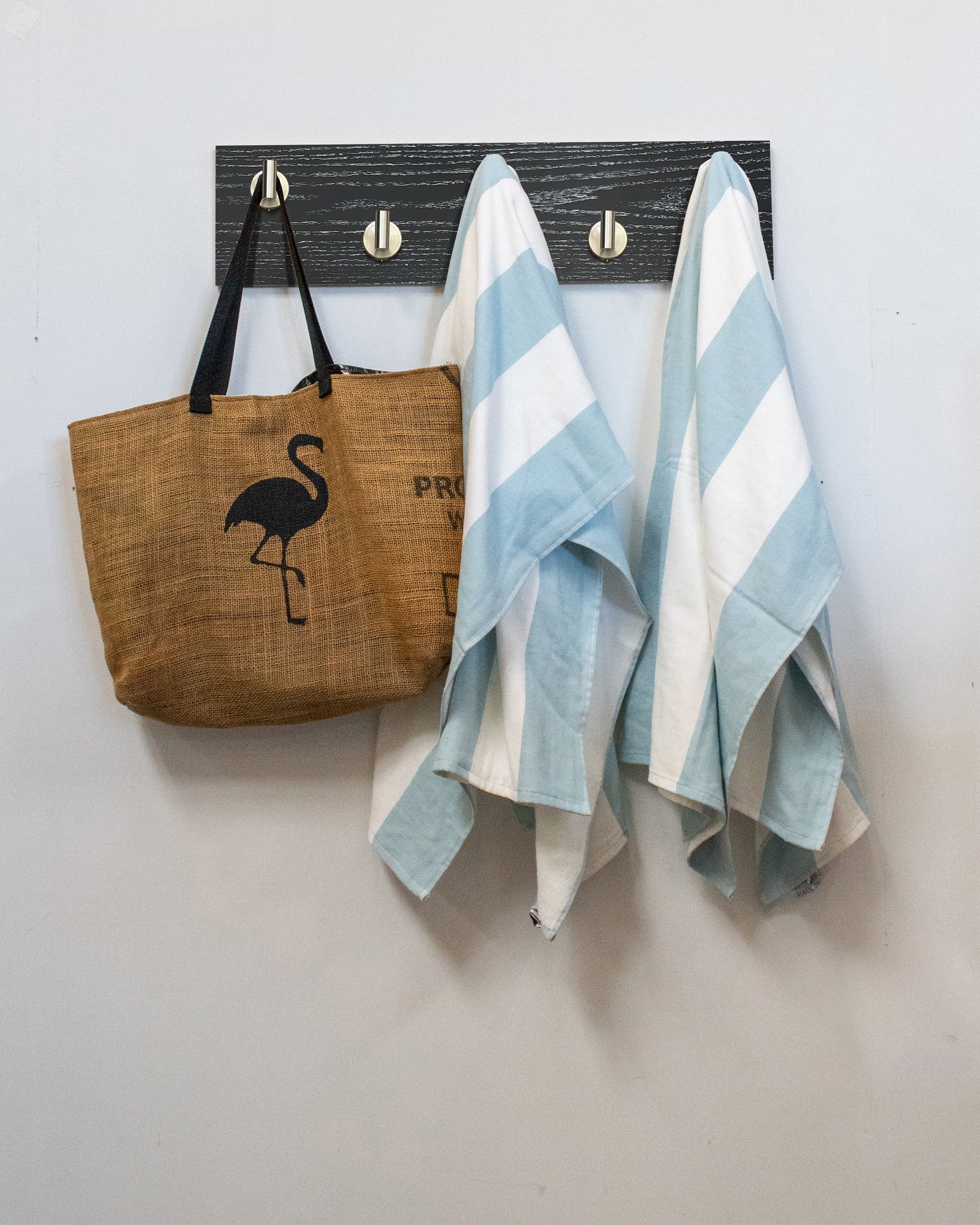 Ebonized cerused oak wall hook rack brown tote bag with flamingo design and two striped towels hanging on 5 satin nickel hooks 