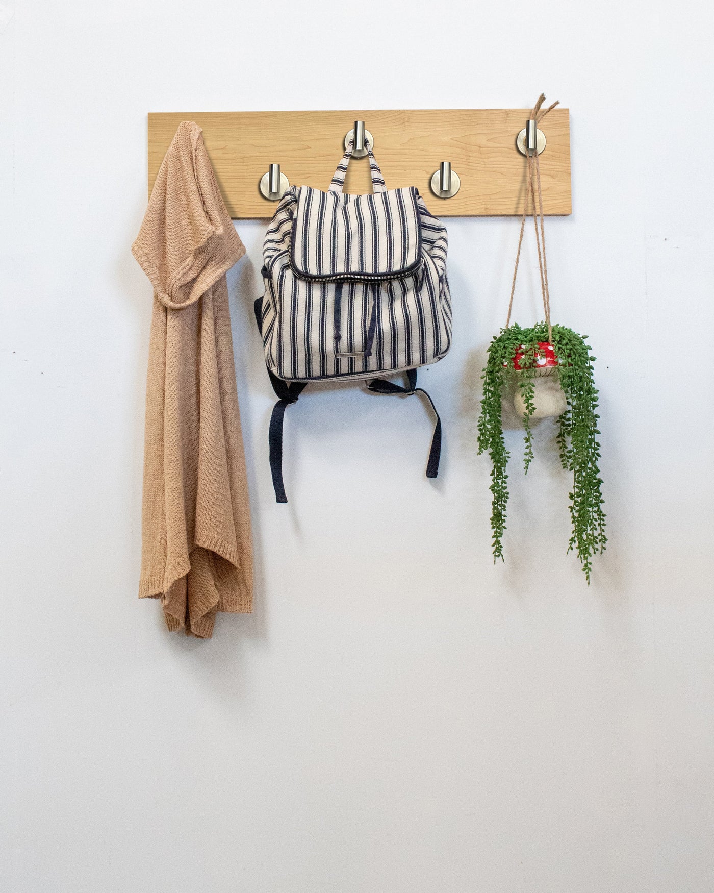 Maple Wood wall hook rack satin nickel hooks with a backpack, coat, and plant