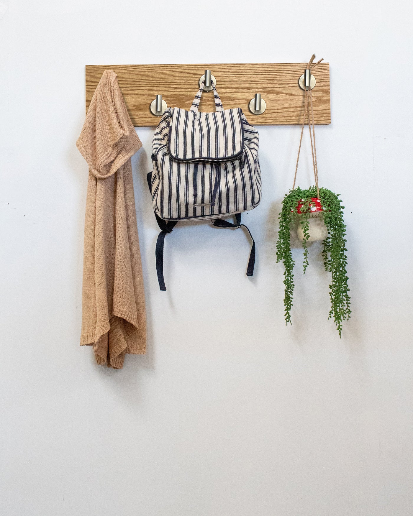 Red Oak wood wall hook rack satin nickel hooks with a backpack, coat, and plant