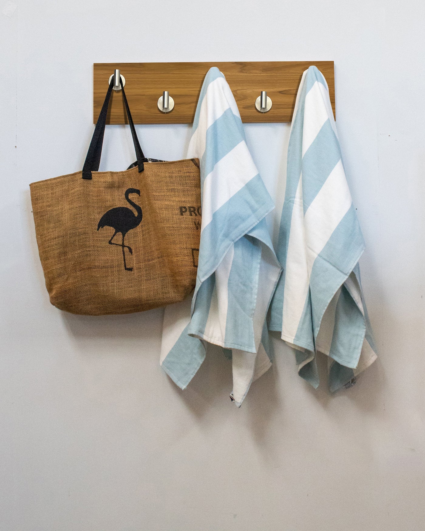 Teak wood wall hook rack brown tote bag with flamingo design and two striped towels hanging on 5 satin nickel hooks 