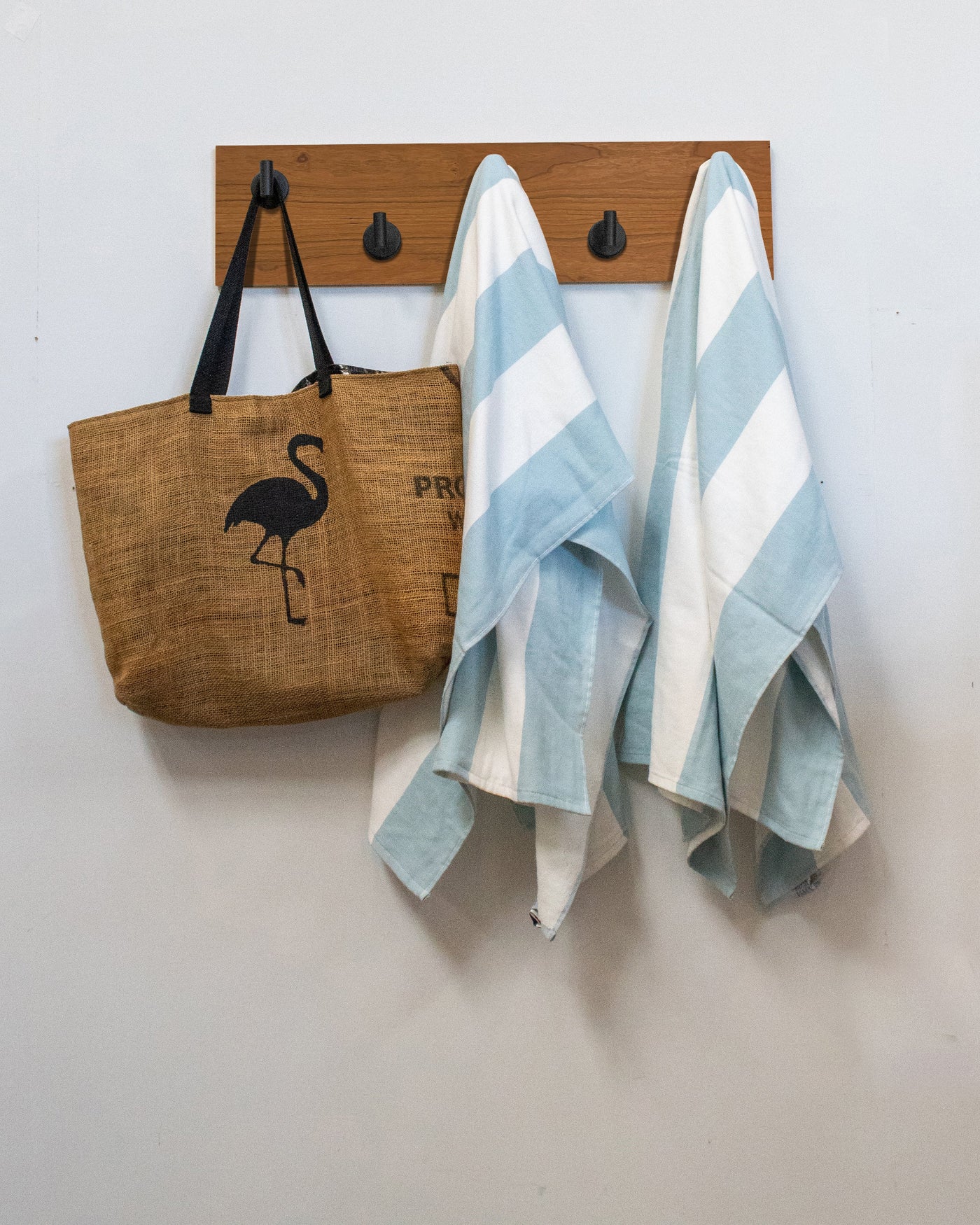 cherry wood wall hook rack brown tote bag with flamingo design and two striped towels hanging on 5 matte black hooks 