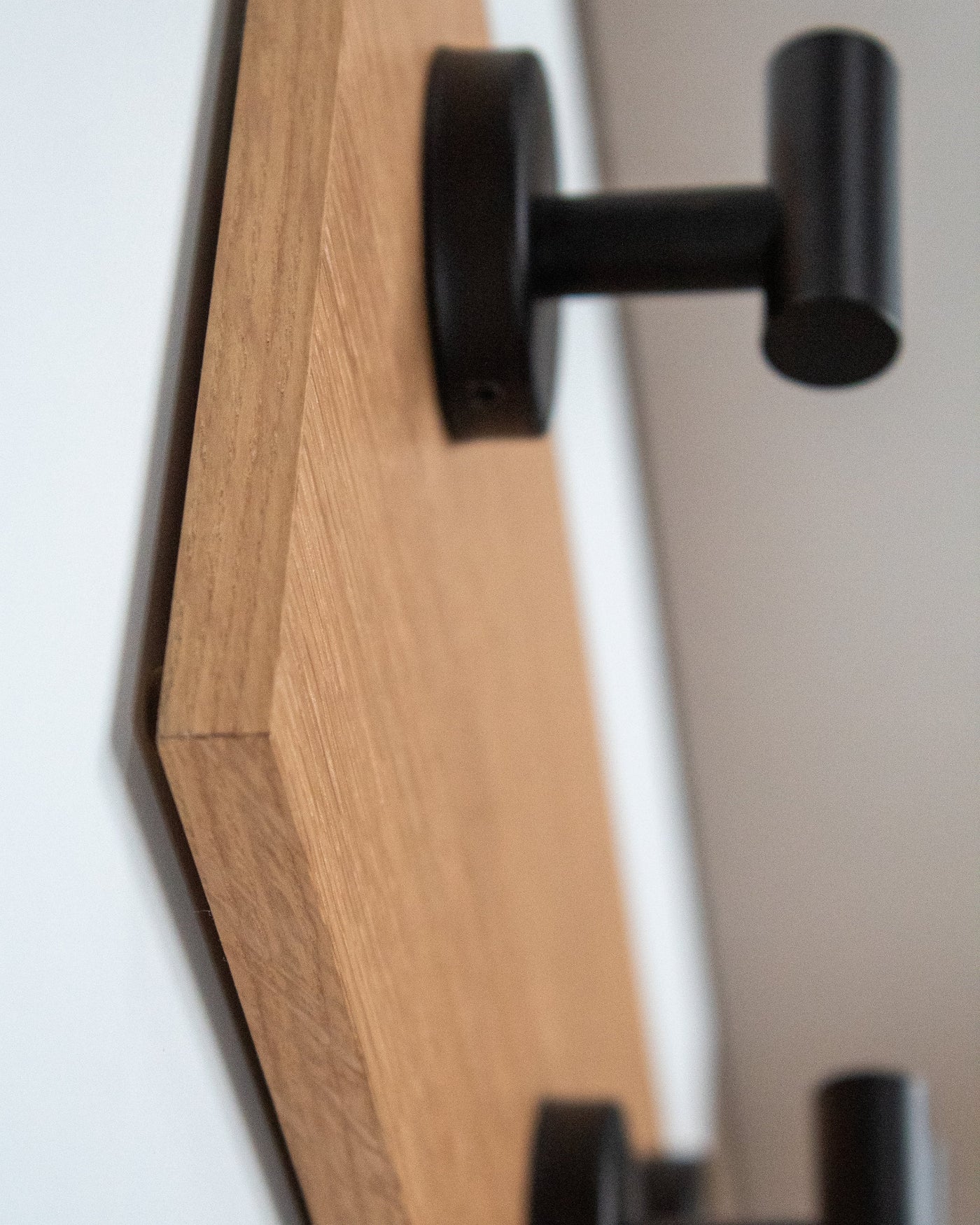 edge detail close up of rift white oak Wood wall hook rack matte black hooks