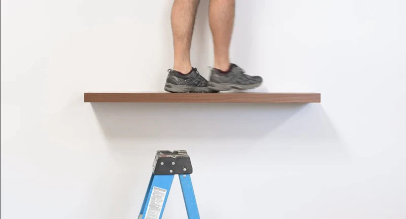 bamboo floating shelf on a wall with a mans feet standing on the floating shelf