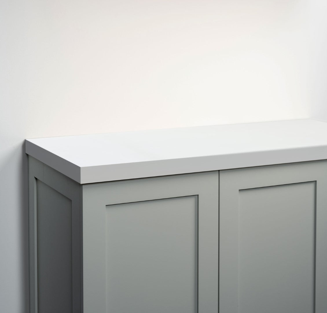 A close-up of a modern gray cabinet with a white painted wood countertop 